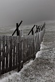 Wooden snow guard in wintry meadow