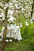 Garland of bunnies between blossoming fruit trees and set table in background