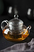 Green tea in a glass teapot