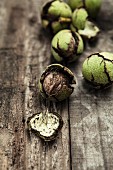 Fresh walnuts with green shells on a wooden surface