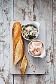 Bowls of prawn salad and herring salad served with baguette (seen above)