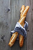 Two baguettes wrapped in a cloth