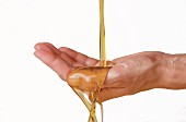 Olive oil running over woman's cupped hand