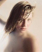 Nude young woman with damp hair; blurred