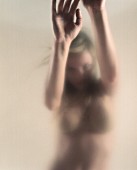 Nude young woman with wind-blown hair; blurred