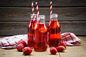Homemade strawberry lemonade in bottles with straws