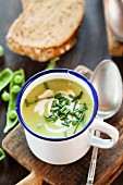 Pea soup with chives in an enamel mug
