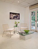 Bright lounge area with wicker chairs, serving trolley and glass table