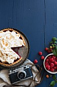 Raspberry pie, sliced, fresh raspberries and a camera