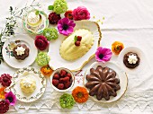 Vanille- & Schokoladenpudding auf mit Blüten dekoriertem Tisch (Aufsicht)