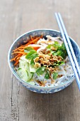 Rice noodles with chicken, vegetables, herbs and roasted onions