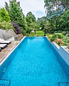 View along infinity pool in landscaped garden