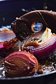 Caramelised red onions with a wooden spoon and caramel threads
