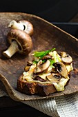 Bruscette al funghi (grilled bread topped with mushrooms) on a wooden scoop