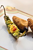 A fried friggitello pepper filled with turmeric couscous and Caciocavallo cheese with a poppyseed crust from the restaurant Farmacia dei sani in Ruffano, Italy