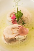 Wolfsbarsch-Rouladen mit Scampi, wilden Zwiebeln und Zucchiniwasser, Laltro Baffo Restaurant in Otranto, Italien
