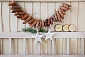 Garland of fir cones on beige board wall