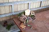 Pine cones, stag ornaments and pillar candle arranged in bowl