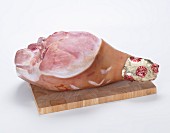 A whole leg of ham on a wooden board