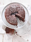 Chocolate cake dusted with icing sugar, sliced