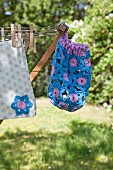Hand-made, blue and purple peg bag hanging from clotheshorse