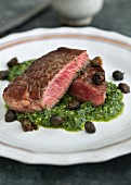Beef steaks on a basil and caper sauce