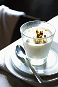 A glass of panna cotta with chopped pistachio nuts
