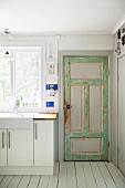 Vintage back door next to white kitchen counter below window