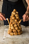 A croquembouche being decorated with caramel threads