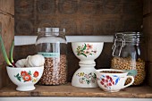 Vintage bowls and storage jars in rustic wine crate used as kitchen shelf