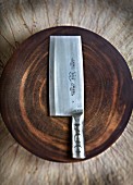 A meat cleaver on a wooden plate (China)