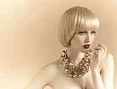 A young woman with platinum blonde pageboy hair style wearing an extravagant necklace