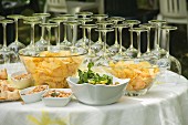 An aperitif buffet with wine glasses, crisps, olives and peanuts