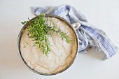 Yeast dough for focaccia with rosemary and thyme in a bowl