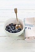 Blueberries in a white bowl with a napkin embroidered with initials