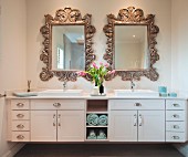 Washstand with twin sinks below mirrors with carved wooden frames