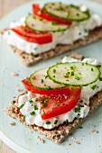 Crispbread topped with cottage cheese, tomatoes, cucumber and chives
