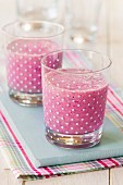 Two fruit smoothies in spotted glasses