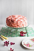 A festive pink cream cake on a cake stand
