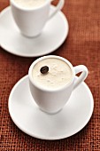 A coffee dessert garnished with a coffee bean in a mocha cup