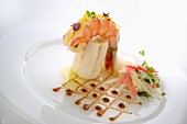 A king prawn on bass fillet with a sauce grid and a vegetable salad