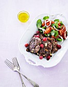 Beef with nuts, olives, raspberries and tomato salad