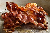 Kross gebratene Baconscheiben, gestapelt in einer Pfanne (Close Up)