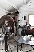 Young couple and dog in wintry living room in log cabin