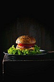 Hausgemachter Hamburger mit schwarzem Sesam auf Metallteller