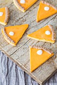 Cookies shaped like slices of pumpkin pie with icing