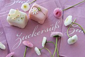 Petit fours with bellis on paper napkins