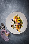 Smoked trout on a mango salad with wasabi cream and edible flowers