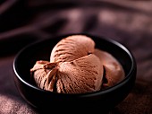 Chocolate ice cream in a black ceramic bowl