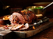 Carved lamb leg with stuffing on a chopping board